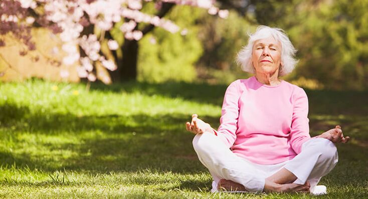 muller de idade avanzada meditando con artrose da cadeira